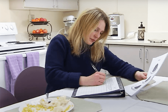 Woman keeping a food journal for a research study.