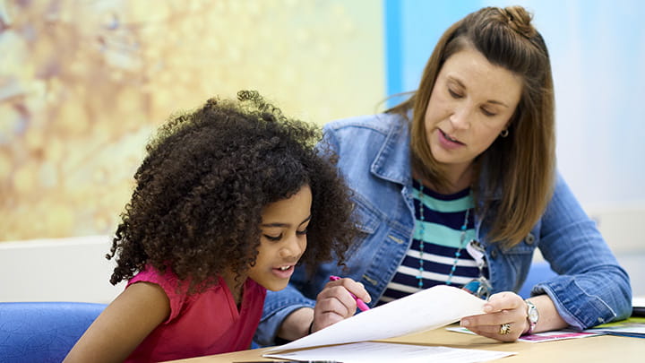 An image of a woman and a child reading.