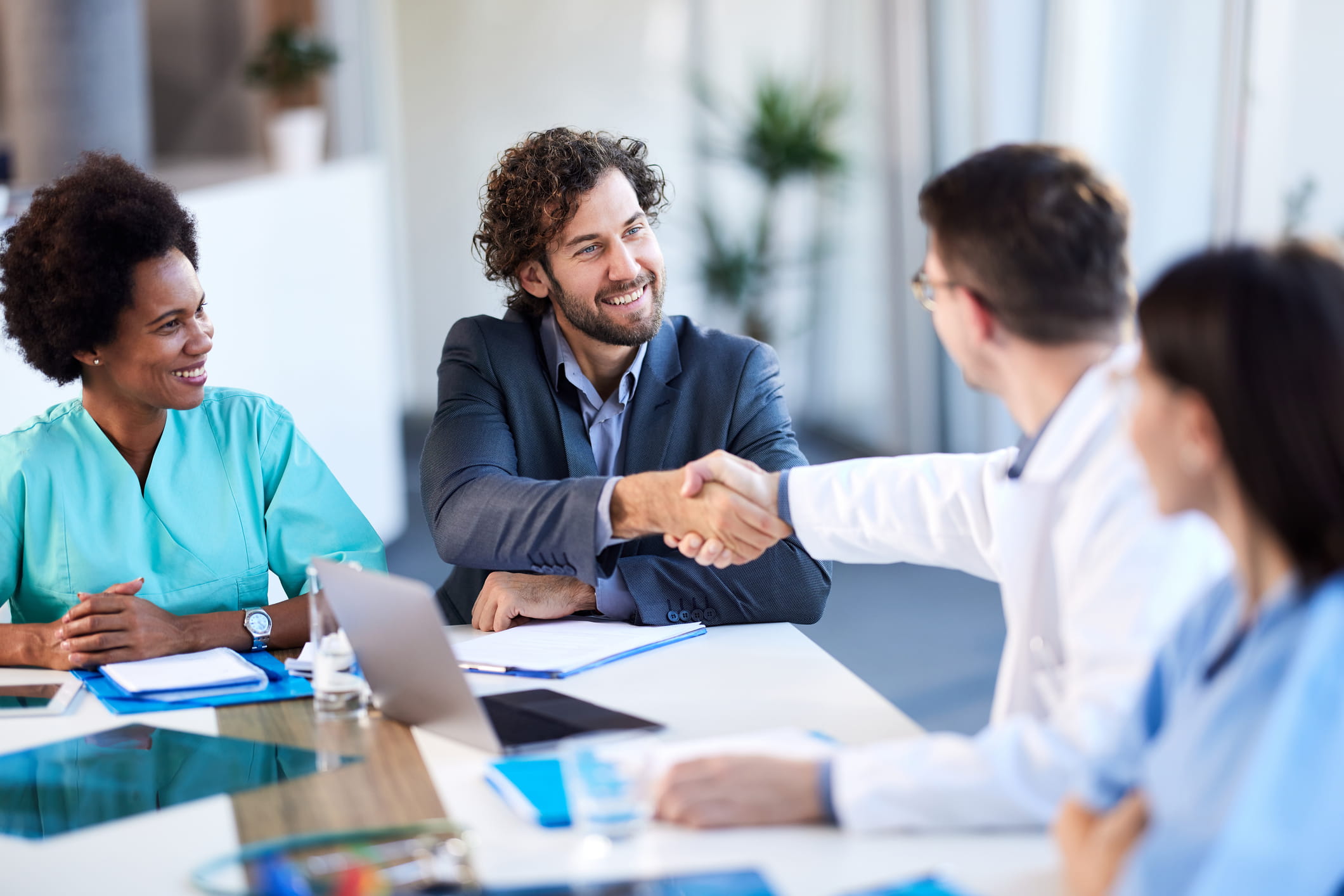 Professionals come to an agreement on licensing terms at a table.