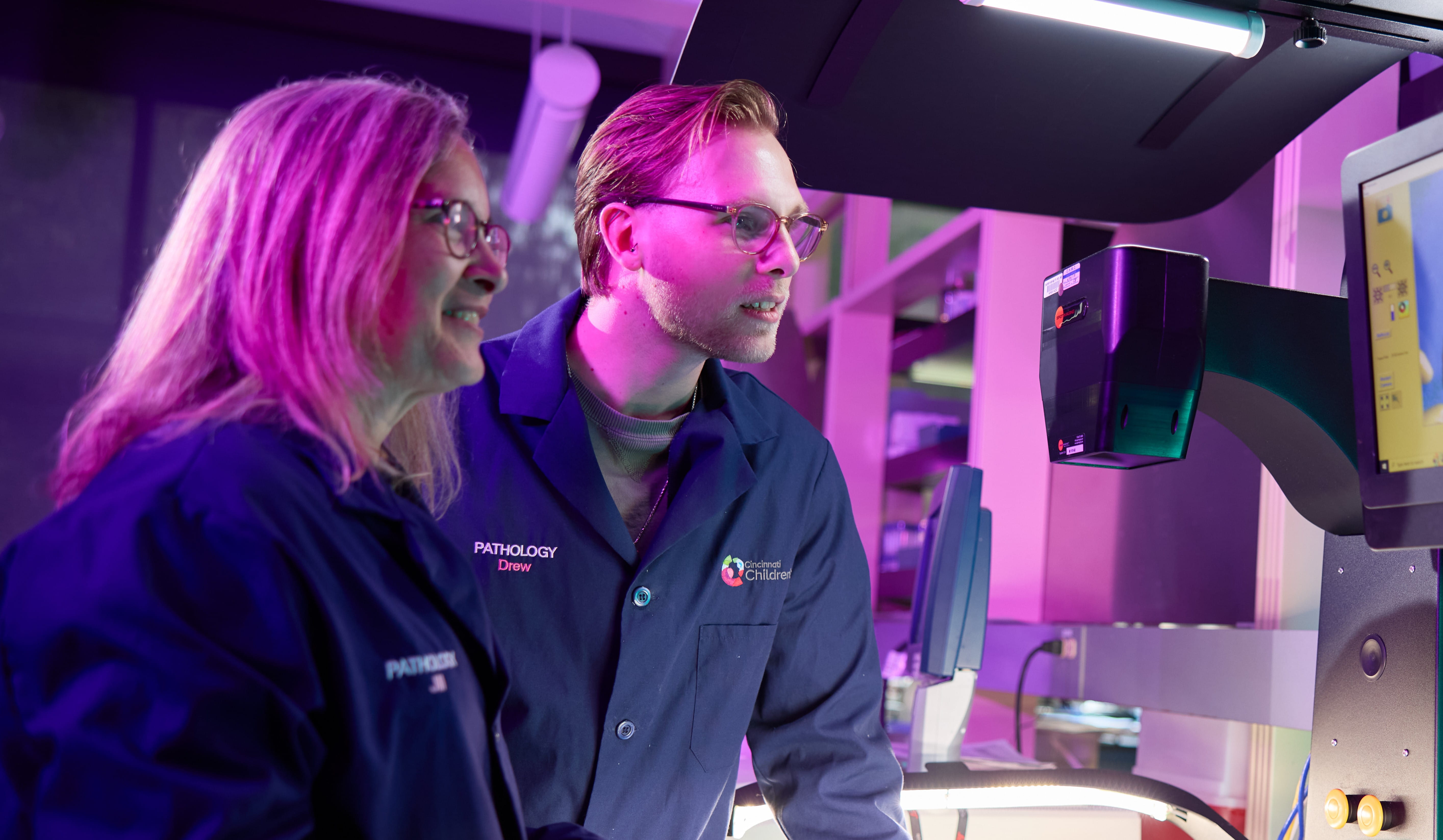 Scientists look at a pathology image and confer over results.