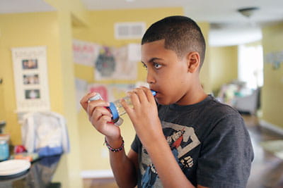 Asthma patient using an inhaler. 