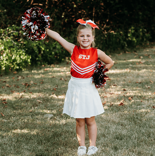 Kennedy smiles in her cheerleading outfit.