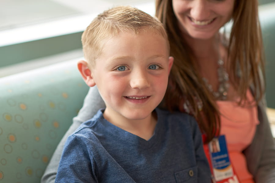 Smiling boy sitting with a nurse.