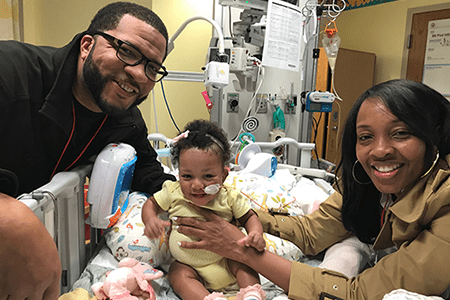 Judea and her parents smile for a family photo.
