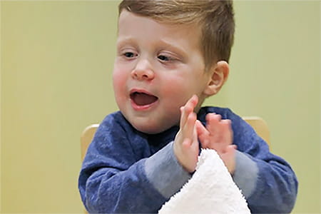 Charlie clapping and smiling.