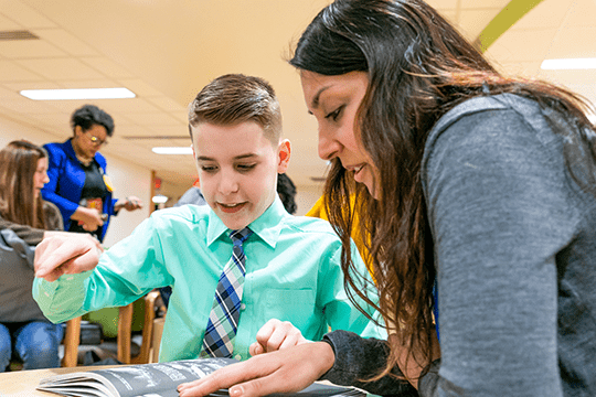 A cerebral palsy patient reading with his doctor.