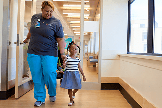 An image of a nurse and a patient walking together.