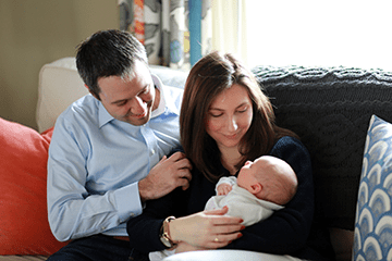 An image of a mom, dad, and their newborn.