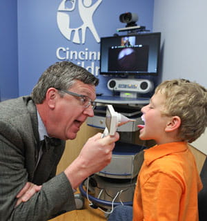 Attending physician S. Andrew Spooner, MD, MS, FAAP, uses an exam camera, a peripheral which is attached to the telemedicine cart, to examine a patient.