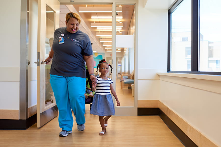 Dental assistant walking with a patient.