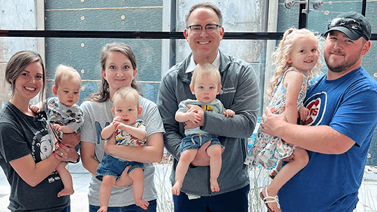 Family and doctor with triplets.