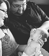 Ruthie being held by her parents.