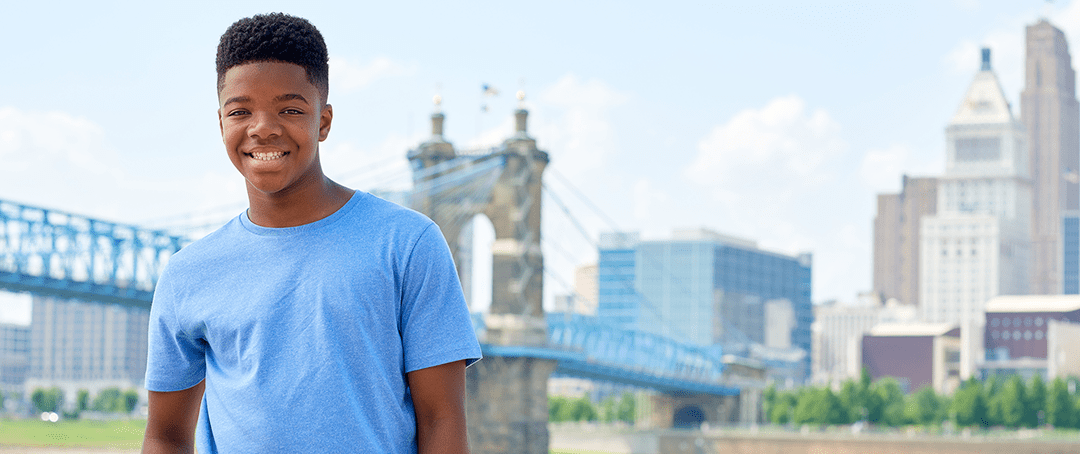 A Headache Center patient smiling by the Roebling Bridge.