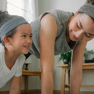 A photo of a mother and daughter doing yoga.