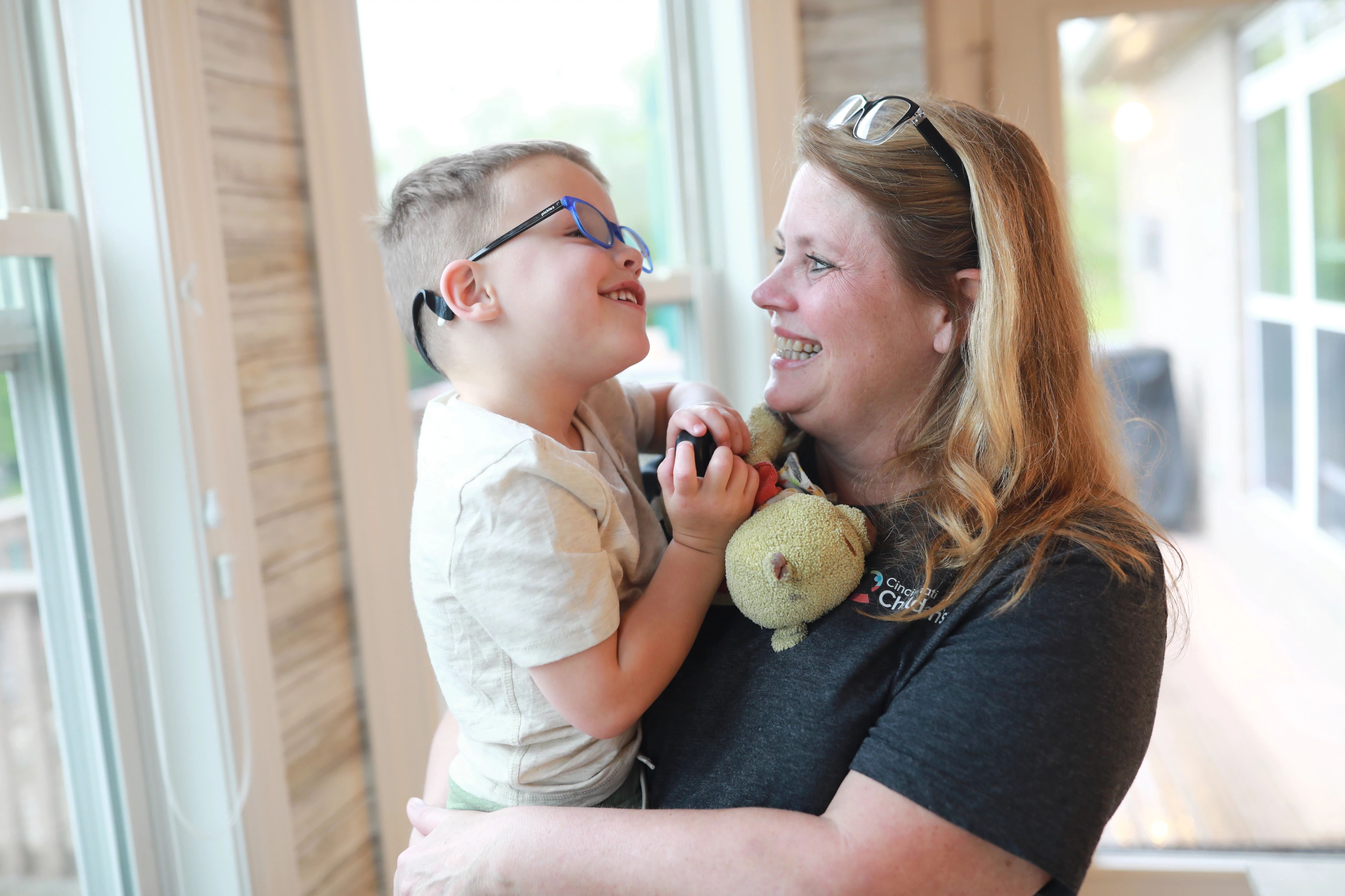 A smiling patient held by an employee.