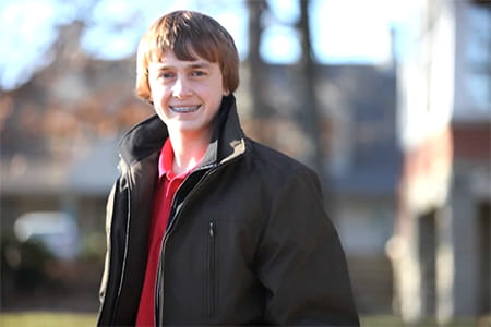 Alex outdoors smiling.