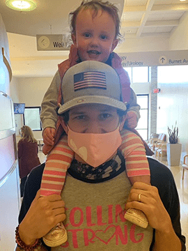 Collins sits on her dad's shoulders.