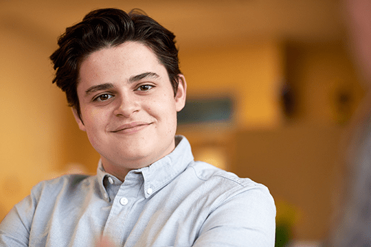 Adolescent boy smiling during therapy.