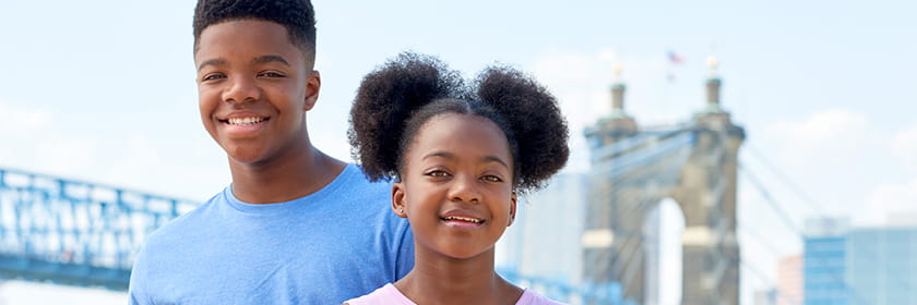 Two neurology patients smiling by the Roebling Bridge.