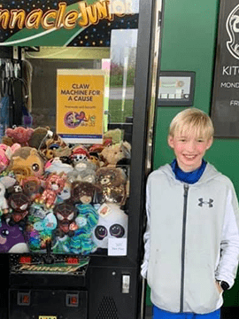 Isaac next to clawmachine.