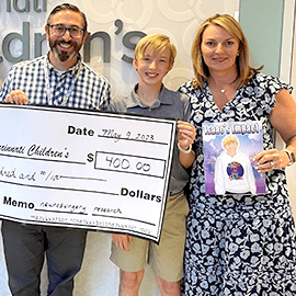 Isaac presents check to Cincinnati Children's.