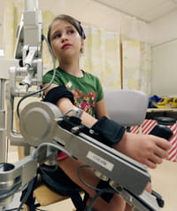 A patient uses the external support device call the Armeo®Spring Pediatric to help build strength and increase range of motion.