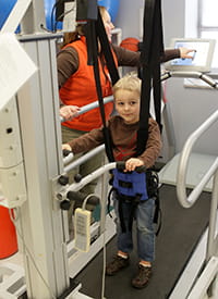 A young patient uses the LifeGait® machine.