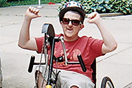Photo of Jason, a patient with RTS, riding a bike.