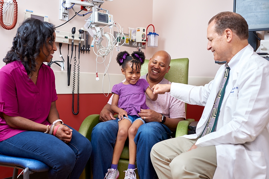 A doctor and family smile together.