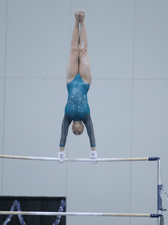 Rachel competes on the bars.