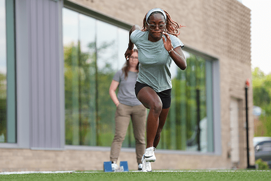 Athlete receives help with sprinting mechanics.