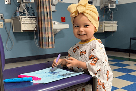 Raegan smiles while drawing.