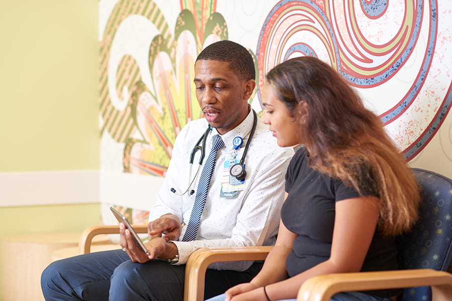 A doctor talking with a teen patient.