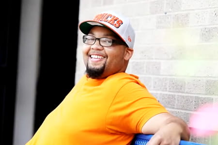 Weight loss surgery patient sitting on a bench.
