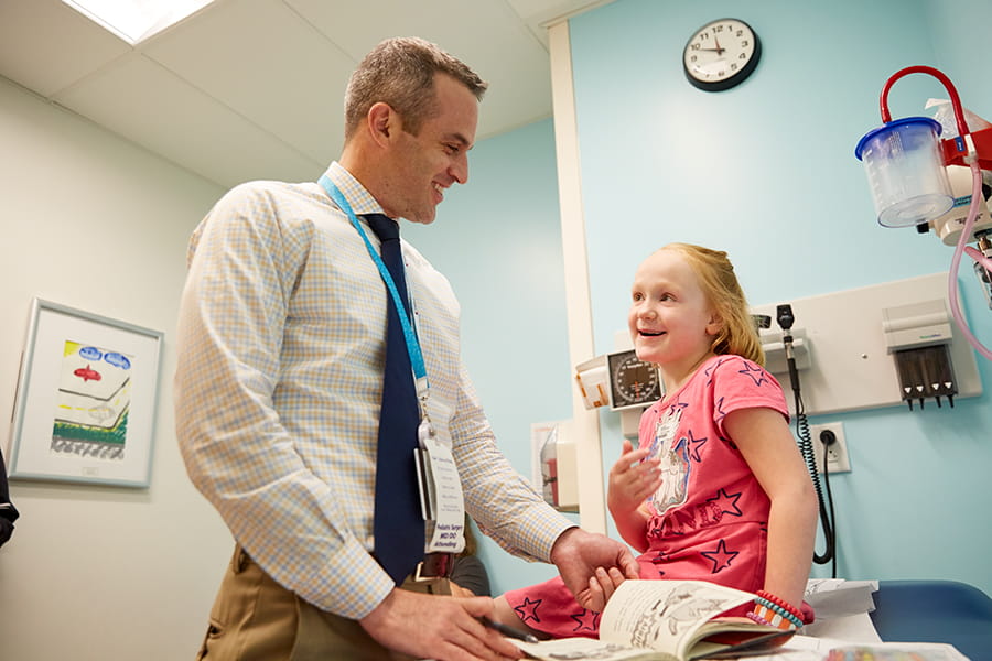 Doctor and child looking at a book together.