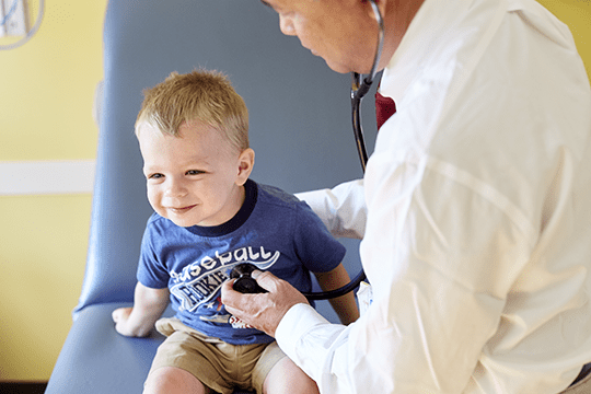 An image of a pediatric patient getting a check-up from his cardiologist.