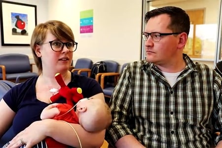 Mother and father sitting with their baby.