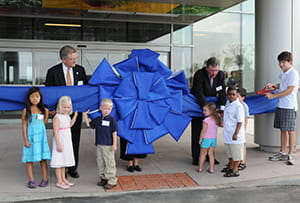 Former President and CEO Jim Anderson (l) and Board Chair Tom Cody get help with the ribbon-cutting duties from some of our patients in 2008.