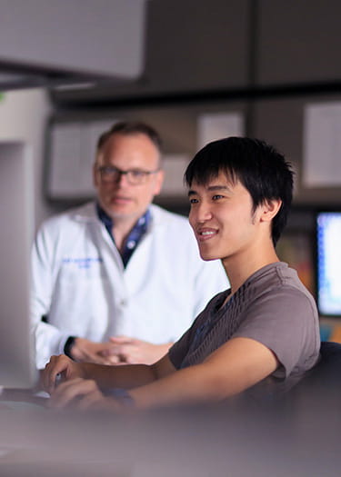 An image of Stephen Trisno and Christopher Mayhew, PhD, in the lab.