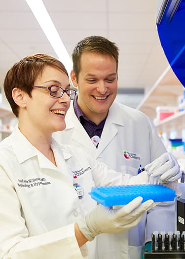 An image of Stephanie Benoit, MD, and James Rose in the lab.