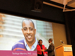 Tes Mersha receiving his award.