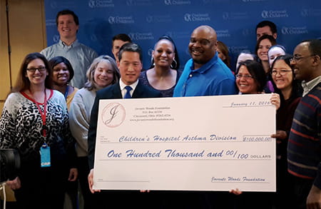 The Woods family presents a check to the Asthma research team.